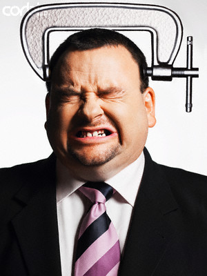 Businessman with Head in Vice --- Image by © moodboard/Corbis